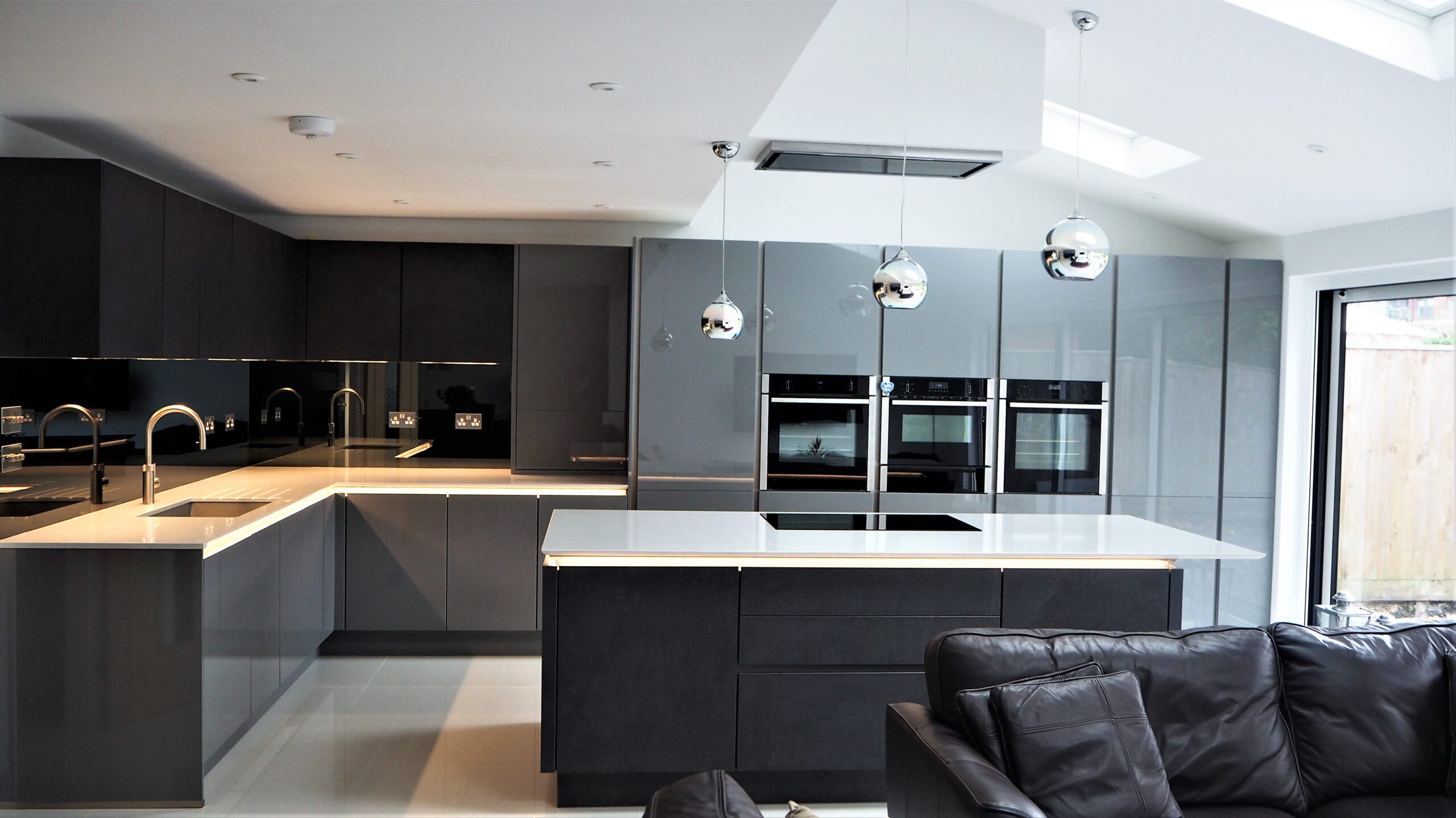 Dark handleless kitchen with island by Glam Kitchens
